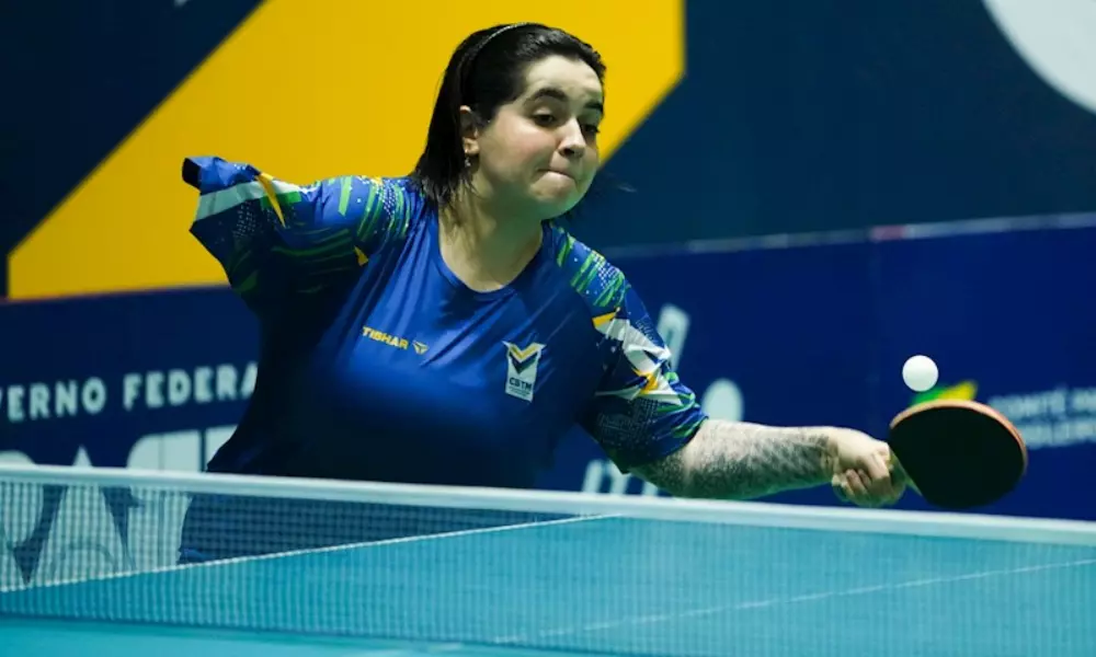 Bruna Alexandre rebatendo bola em partida de tênis de mesa