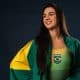Giovanna Pedroso, atleta dos saltos ornamentais, posa enrolada na bandeira do Brasil