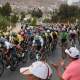 Acima de expectador com camiseta rosa, aparece Victor Paula com uniforme da seleção brasileira em meio ao pelotão na Volta da Colômbia de ciclismo de estrada