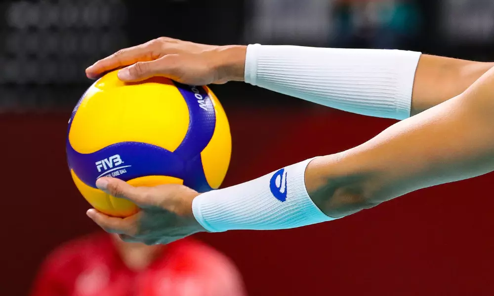 Mãos negras segura bola de vôlei. CBV divulga mudança de regulamento para aumentar punição para discriminação