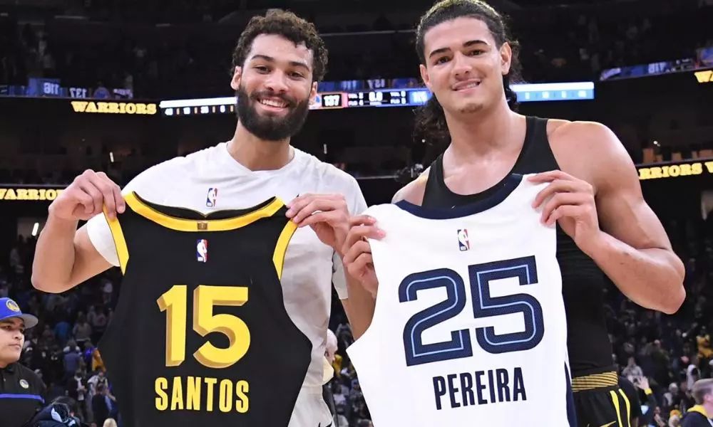 Brasileiros Mãozinha e Gui Santos trocando camisas após partida pela NBA (Foto: Reprodução/X/CBB)