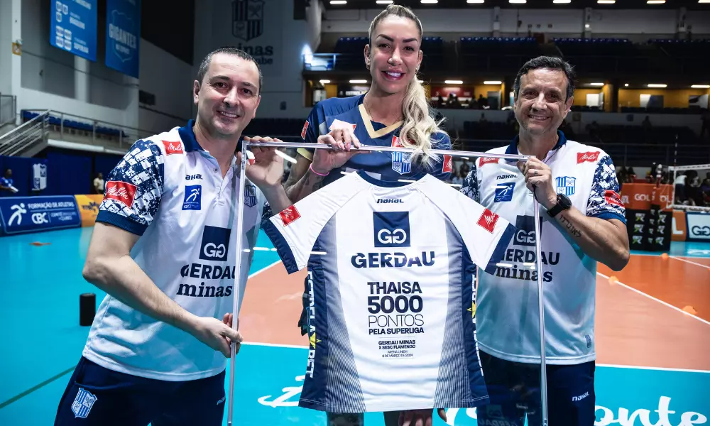 Thaísa posa para foto segunrando mural com a camisa especial