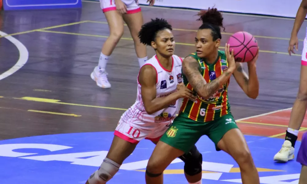 Sassá, do Sampaio Basquete, carrega a bola marcada por atleta de Blumenau