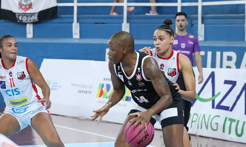 Na imagem, jogadora do Corinthians girando para a cesta em cima da marcação do Ituano.