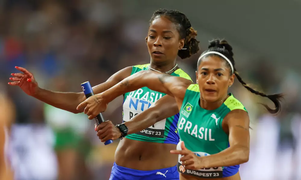 Ana Azevedo recebendo passagem de bastão de Vitória Rosa no revezamento 4x100m feminino