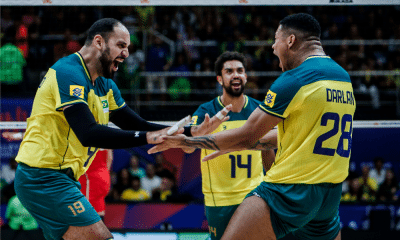 Darlan e Maurício Borges estão a frente da imagem, vibrando, com Cachopa ao fundo, durante partida entre Brasil e Sérvia na Liga das Nações de vôlei masculino, a VNL 2024