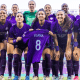 Jogadoras do Orlando Pride posam para foto segurando camisa de Luana Bertolucci antes de jogo da NWSL