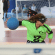 Christiane, artilheira da Adevibel e do Regional, é fotograda por trás do gol da equipe mineira no instante em que faz o giro do arremesso, com o braço direito segurando a bola. Ela veste camisa verde de manga longa com o número 2 em preto na altura do peito. Foto: Renan Cacioli/ CBDV.
