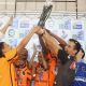 Equipe da Acelgo ergue o troféu do Regional Centro-Norte com vários atletas tocando na taça, sustentada principalmente nas mãos do técnico Fabrício Gomes. Fotos: Renan Cacioli/ CBDV.