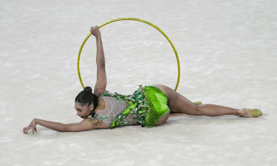 Babi Domingos, comandada por Márcia Naves, segura arco durante apresentação da ginástica rítmica