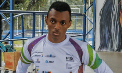 Leandro Viana olha para foto após pódio no Grand Prix de Paris de atletismo paralímpico, junto com Alex Felix de Souza