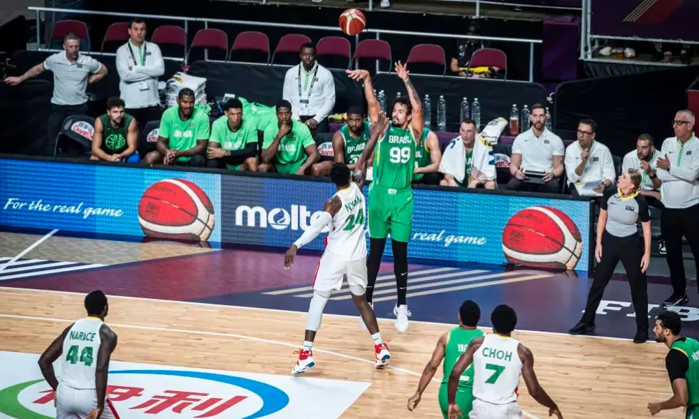 Lucas Dias arremessando de três pontos em jogo do Brasil contra Camarões no Pré-Olímpico de basquete masculino