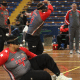 Time masculino do IRM no Regional Sul de Goalball. Um dos atletas está deitado no chão em posição de defesa, enquanto o ouro está de pé após lançar a bola