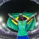 Alison dos Santos comemora com a bandeira do Brasil a conquista da medalha de bronze nos 400 m com barreiras nos Jogos Olímpicos de Paris-2024