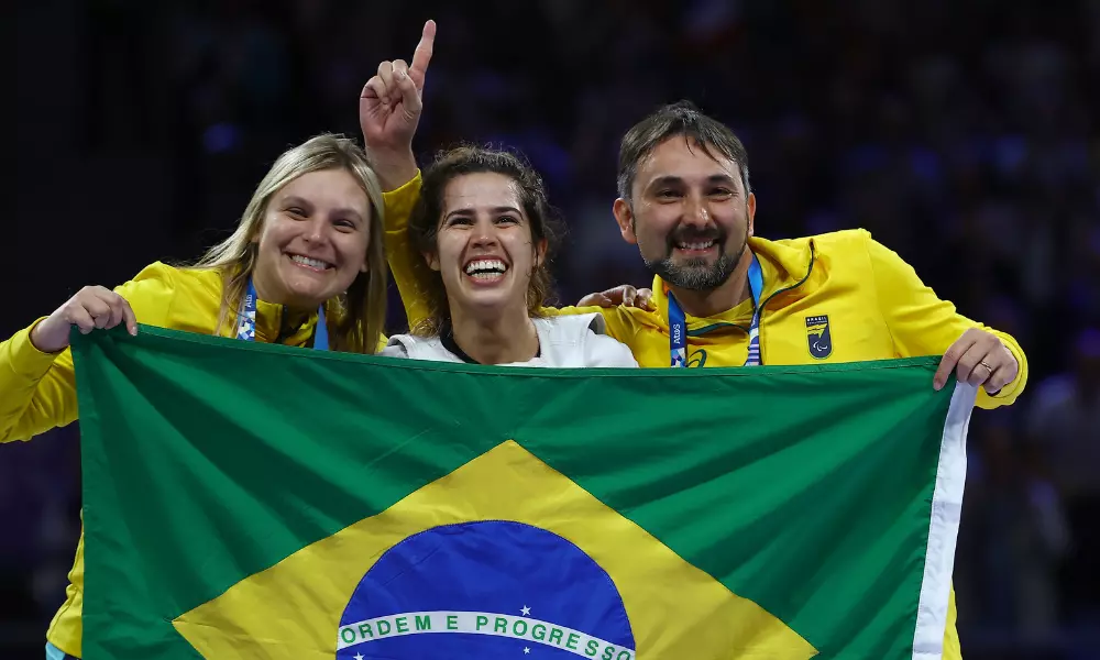 Ana Carolina Moura, Rodrigo Ferla e Elisa Pilarski com a bandeira do Brasil em Paris-2024