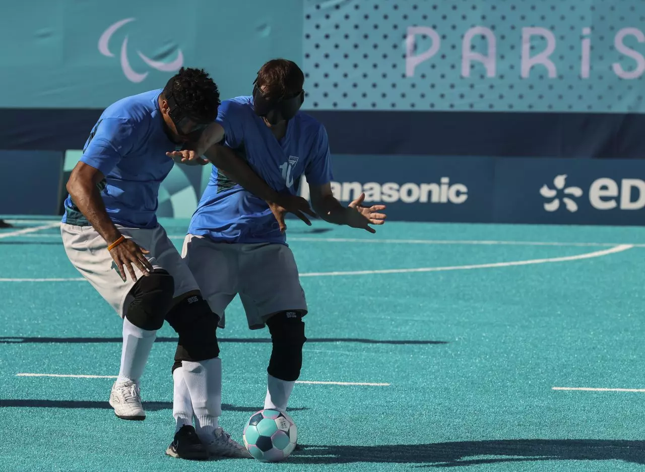Ricardinho disputa bola com Nonato em partida no campo de futebol de cegos