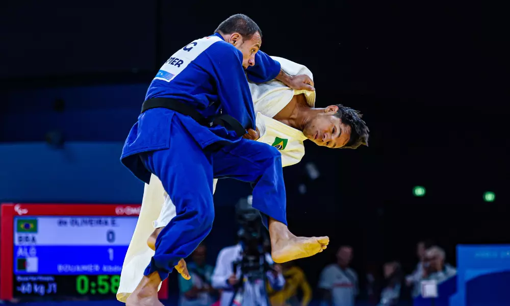 Elielton Oliveira, de judogi branco, é projetado por atleta argelino de azul no judô da Paralimpíada de Paris-2024