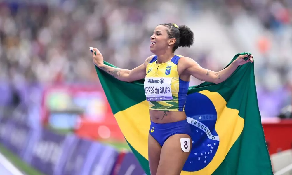 Rayane Soares comemora com a bandeira do Brasil a conquista da medalha de ouro dos 400 m rasos T13 nos Jogos Paralímpicos de Paris-2024