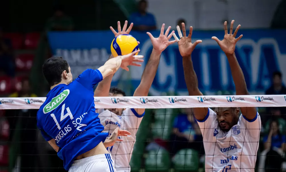 Douglas Souza, do Sada Cruzeiro, ataca contra bloqueio duplo do Minas em partida da Superliga de vôlei masculino