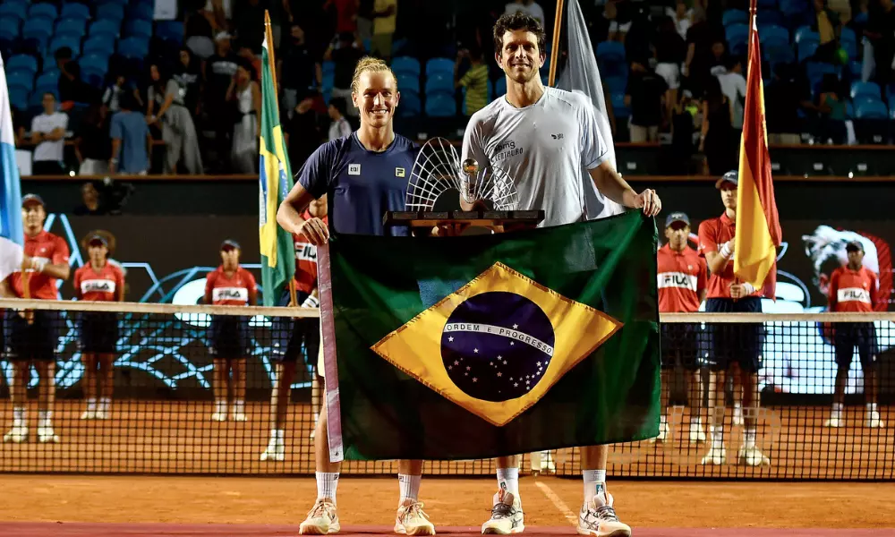 Marcelo Melo e Rafael Matos posam para foto com bandeira do Brasil e troféu do Rio Open