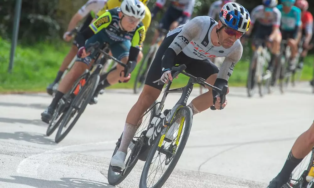 Na imagem, Henrique Avancini pedalando no meio do pelotão, na estrada.