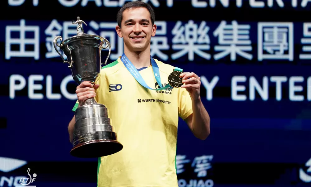 Hugo Calderano posa para foto com o troféu da Copa do Mundo de tênis de mesa