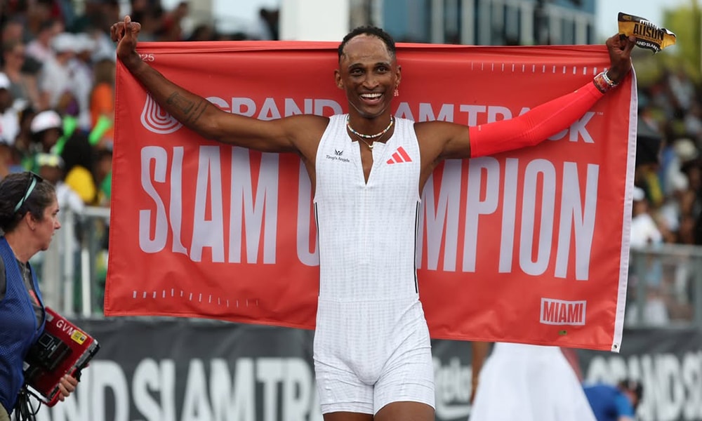 Na imagem, Alison dos Santos comemorando com a bandeira de campeão do Grand Slam Track.