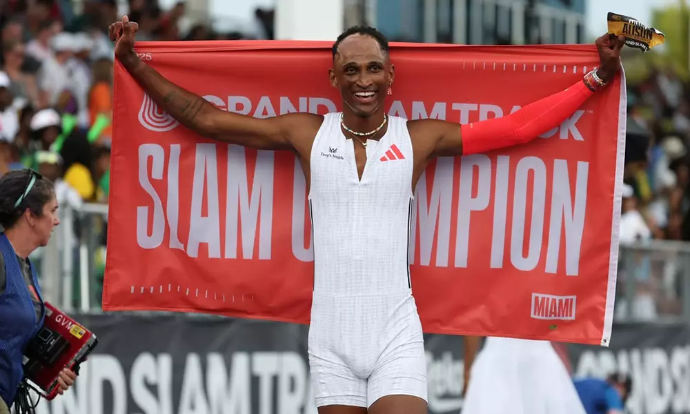 Na imagem, Alison dos Santos comemorando com a bandeira de campeão do Grand Slam Track.