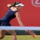 Luisa Stefani tenta alcançar a bola para atacá-la com um backhand no WTA 500 de Queen's