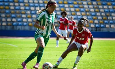 Na imagem, jogadora do Juventude avançando com a bola contra a marcação Colorada.