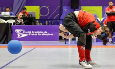 Na imagem, atleta do Sesi arremessando a bola de goalball em jogada por debaixo das pernas.