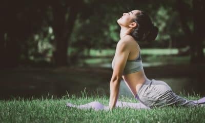 Pessoa realizando recuperação muscular ativa após o treino com alongamento leve ao ar livre