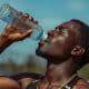 Pessoa se hidratando durante treino ao ar livre em dia quente