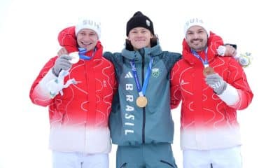 Lucas Pinheiro posa ao lado dos suíços que completaram o pódio do esqui alpino nos Jogos Olímpicos de Milão-Cortina 2026