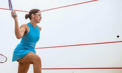 Na imagem, Laura Silva prestes a dar mais um golpe na bolinha com sua raquete contra a parede na quadra de squash.