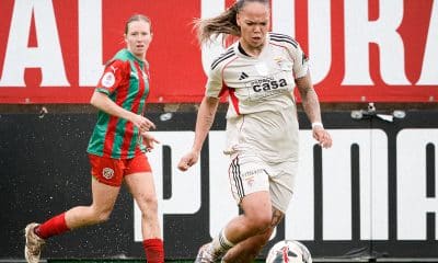 Na imagem, Nycole conduzindo a bola no campo com chuva.