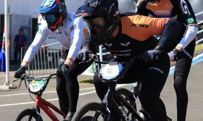 Na imagem, Bruno Cogo, de laranja e preto, durante a competição com sua bicicleta.