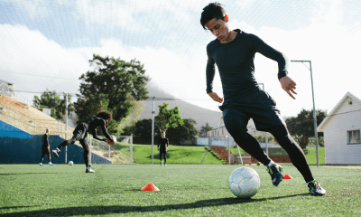 Jogador mudando rapidamente de direção durante disputa de bola, com foco em agilidade, controle corporal e reação.